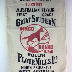 May include: A rectangular off-white fabric sack featuring black and red printed text and graphics. The text reads BAKERS FLOUR, 10 kg NET, AUSTRALIAN FLOUR FIRST GRADE, GREAT SOUTHERN, DINGO BRAND H/240, ROLLER FLOUR MILLS LTD, NORTH FREMANTLE WEST AUSTRALIA.