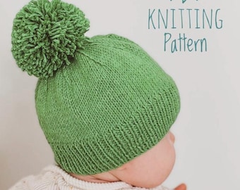 May include: A green knitted hat with a fluffy pom pom on top. The hat is being worn by a baby. The text "KNITTING Pattern" is written above the hat.