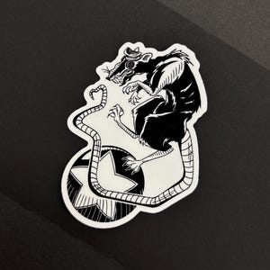 May include: Black and white sticker featuring a rat wearing a hat, perched atop a star-shaped design. The rat has a long tail and is rendered in a detailed, illustrative style. The sticker is die-cut with a white border.