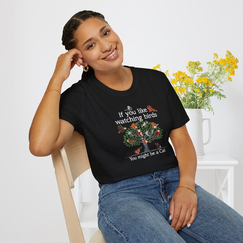 Puede incluir: Camiseta negra con un gr&aacute;fico blanco de un &aacute;rbol con p&aacute;jaros y el texto "Si te gusta observar p&aacute;jaros Puede que seas un gato."