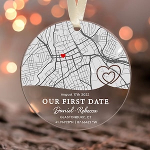 May include: A clear glass ornament with a map of Glastonbury, CT, and the text "August 17th 2022 Our First Date Daniel-Rebecca Glastonbury, CT 41.96928°N | 87.66421 "W" printed on it. The ornament features a red heart marking the location of the first date and a brown heart design.