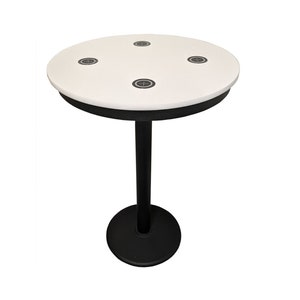 May include: A round, white table with a black rim and a single black pedestal base. The tabletop has four recessed, circular insets with a crosshair design. The table is suitable for various settings.