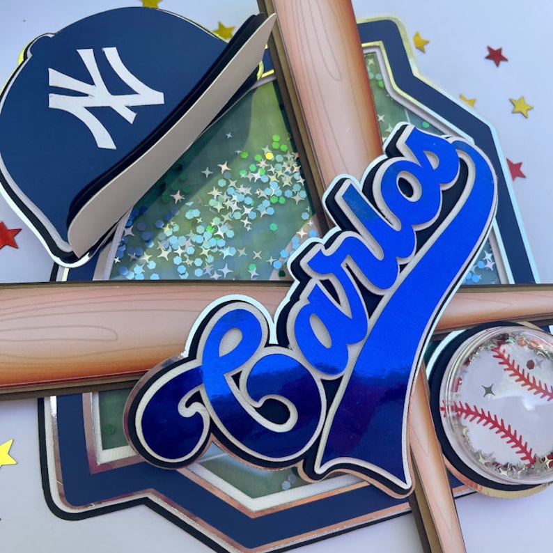Pu&ograve; includere: Un cappello da baseball blu e bianco con il logo dei New York Yankees, uno striscione con il nome di baseball blu con il nome "Carlos", due mazze da baseball di legno e una palla da baseball di plastica trasparente con cuciture rosse.