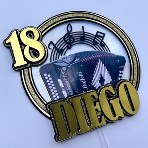 Puede incluir: Topper para pastel dorado y negro con el número 18, el nombre Diego, notas musicales y un acordeón negro y rojo.