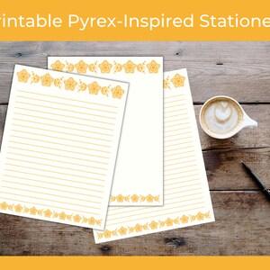 May include: Printable stationery featuring a floral border design in a yellow-orange color. The stationery is on a wooden surface with a cup of coffee.