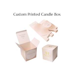 Può includere: Diverse scatole di candele stampate personalizzate sono esposte su sfondo bianco. Una scatola è aperta, rivelando l'interno, mentre un'altra è assemblata. Le scatole sono di colore beige chiaro con testo dorato e le parole "Custom Printed Candle Box" in alto.