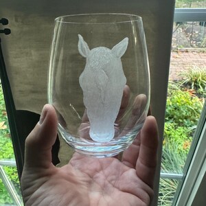 Puede incluir: Una copa de vino de vidrio transparente con un dise&ntilde;o grabado de una cabeza de caballo. La cabeza del caballo est&aacute; mirando hacia atr&aacute;s.