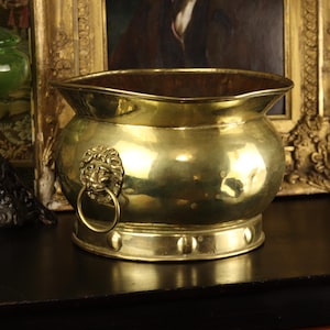 May include: A white ceramic mug with a black handle and the text "But First, Coffee" in a black, handwritten-style font. The mug is on a white surface.