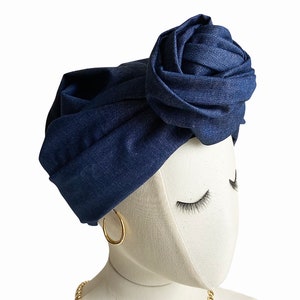 May include: A dark blue denim turban with a large rose-shaped knot on top.