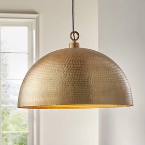 May include: A gold hammered metal pendant light fixture with a round dome shape.