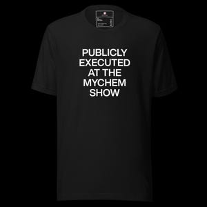 Puede incluir: Camiseta negra con el texto blanco "PUBLICLY EXECUTED AT THE MYCHEM SHOW". La camiseta tiene cuello redondo y mangas cortas. El texto está centrado en la parte delantera.