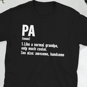 May include: Black t-shirt with white text defining "PA" as "Like a normal grandpa, only much cooler." The definition also includes "See also: awesome, handsome." The shirt is a short-sleeved crew neck.