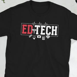 May include: Black t-shirt with the text "ED TECH" in a white and red rectangular design. The design includes a medical symbol, a heartbeat line, and other medical-related icons. The shirt is short-sleeved.