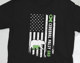 May include: Black t-shirt featuring a graphic of the American flag with a green ribbon and a bear. The text "CEREBRAL PALSY DAD" is printed vertically on the right side of the flag. The bear is white with a green outline.