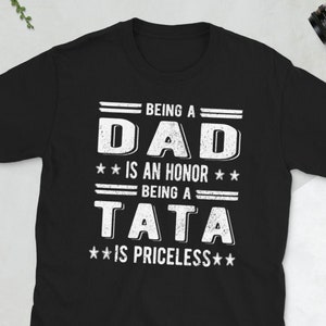 May include: Black t-shirt with white text that reads "Being a Dad is an honor. Being a Tata is priceless."