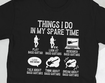 May include: A black t-shirt with white text that reads "Things I do in my spare time". The text is accompanied by illustrations of a person playing a bass guitar, a person looking at bass guitars, a laptop with a bass guitar on the screen, a thought bubble with a bass guitar, and a thought bubble with a bass guitar and the text "I love bass guitars".