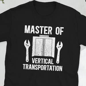 May include: Black t-shirt with white text that reads "Master of Vertical Transportation" with a graphic of a lift and two spanners.