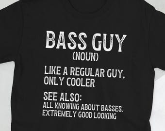 May include: Black t-shirt with white text that reads "BASS GUY (NOUN) LIKE A REGULAR GUY, ONLY COOLER SEE ALSO: ALL KNOWING ABOUT BASSES, EXTREMELY GOOD LOOKING"