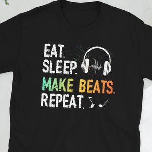 May include: Black t-shirt with a colorful graphic that reads "Eat. Sleep. Make Beats. Repeat." with a pair of headphones and musical notes.