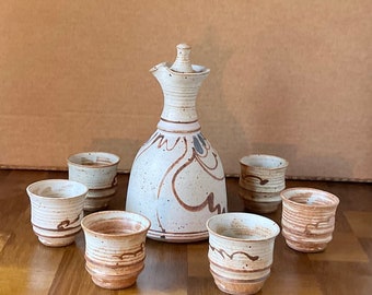 Studio Pottery Shino Decanter Set avec 6 tasses et bouchon, signé Hank 1977. Belle carafe en grès rustique moderne avec intérieur vitré.