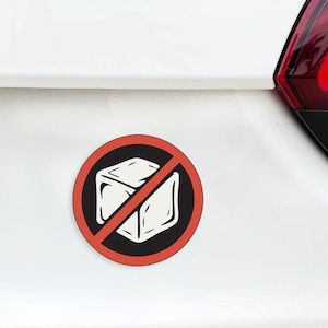 May include: A round sticker with a red border and a white ice cube crossed out with a red diagonal line. The ice cube is on a black background. The text at the bottom says "NOT SCALED TO SIZE, COLORS MAY DISPLAY DIFFERENTLY ON YOUR MONITOR THAN WHAT IS ACTUALLY PRINTED."