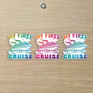 May include: Three colorful stickers with the text "MY FIRST CRUISE". Each sticker features a cruise ship sailing on waves, with a rainbow-colored sky. The stickers are in shades of green, pink, and blue.