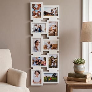 Puede incluir: Un marco de fotos tipo collage vertical en color blanco con múltiples aberturas, que presenta diez espacios rectangulares dispuestos en un patrón escalonado. El marco contiene varias fotografías familiares, incluyendo retratos.