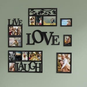 Può includere: Una decorazione murale nera con le parole "LIVE", "LOVE" e "LAUGH" con cornici per foto. Le cornici contengono varie foto. La decorazione è montata su una parete verde chiaro, con un mobile in legno e una poltrona beige in primo piano.