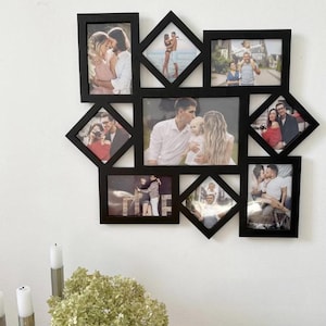 Könnte beinhalten: Ein schwarzer Mehrfach-Fotorahmen mit verschiedenen Familienfotos. Der Rahmen hat ein geometrisches Design mit rechteckigen und rautenförmigen Öffnungen. Die Fotos zeigen Paare, Familien und Einzelpersonen in verschiedenen Umgebungen. Der Rahmen ist an einer weißen Wand befestigt.