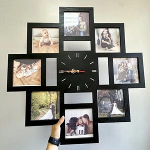 May include: Black wall clock with multiple photo frames in a cross shape. The clock has a gold-colored center and red second hand. The frames contain various family photos.
