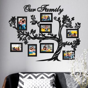 May include: Black silhouette of a family tree with the words "Our Family" at the top. The tree has eight black picture frames with family photos inside. The frames are arranged around the tree branches.