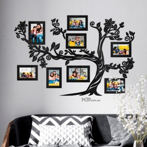 May include: Black silhouette of a tree with branches that hold eight black picture frames. The frames are filled with family photos. The tree is mounted on a white wall. The text "M39.com.ua" is at the bottom of the image.