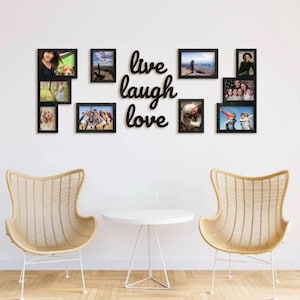 Può includere: Un collage fotografico a parete con cornici nere di varie dimensioni, disposte attorno alla frase in corsivo "live laugh love". Le cornici contengono fotografie. In primo piano, due sedie in vimini e un tavolino bianco.