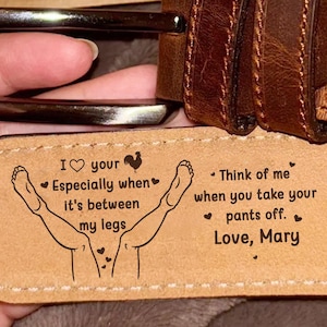 May include: A brown leather belt with a silver buckle. The inside of the belt has a humorous message and a drawing. The text reads: "I love your, Especially when it's between my legs. Think of me when you take your pants off. Love, Mary."