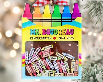 Może przedstawiać: Spersonalizowana ozdoba w kształcie kredek dla nauczyciela, z napisem "MS. BOUDREAU KINDERGARTEN 2024-2025" i imionami uczniów. Ozdoba ma kolorowy wzór kredek i czerwoną i białą kratkowaną kokardę.