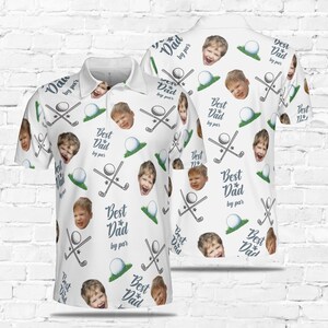 May include: White golf-themed polo shirt with a repeating pattern of golf clubs, golf balls, and a child's face. The text "Best Dad by par" is repeated throughout the pattern.