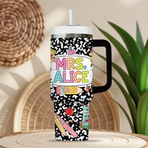Peut inclure: Un gobelet isotherme blanc et argent&eacute; avec une poign&eacute;e et une paille noires. Le gobelet pr&eacute;sente un motif de cahier d'&eacute;colier noir et blanc avec le texte "MRS. ALICE TEACH" en lettres color&eacute;es. Des illustrations sur le th&egrave;me de l'&eacute;cole sont &eacute;galement pr&eacute;sentes.