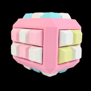 Könnte beinhalten: Ein pastellfarbenes Würfelpuzzle mit einem rosa Rahmen und bunten Blöcken. Die Blöcke sind in Rosa-, Weiß-, Gelb- und Blautönen gehalten. Das Puzzle ist vor einem schwarzen Hintergrund platziert.