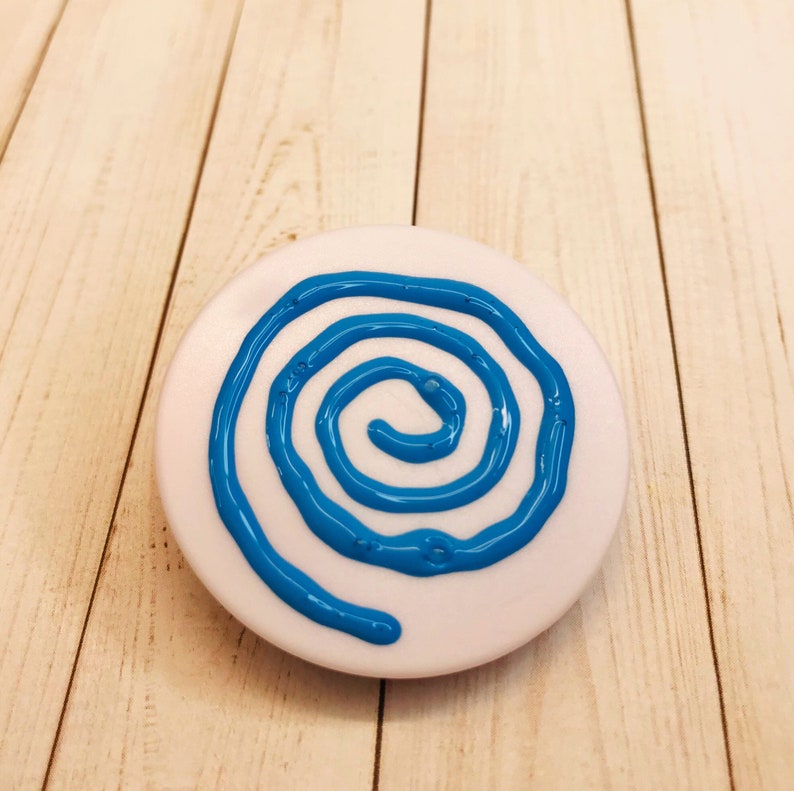 Op de afbeelding: Een witte ronde schijf met een blauw spiraalontwerp dat op het oppervlak is geschilderd.