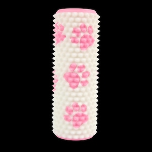 Op de afbeelding: Een wit en roze hondenspeeltje met een cilindrische vorm. Het speeltje heeft een textuuroppervlak met kleine bobbels en roze pootafdrukken. De uiteinden zijn ook roze. Het speeltje is ontworpen voor huisdieren.