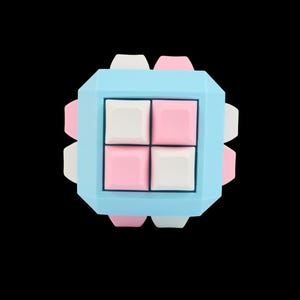 Puede incluir: Un objeto geométrico en forma de cubo de colores pastel. El cubo tiene un marco azul claro con cuatro botones cuadrados en el centro, dos rosas y dos blancos. Las esquinas del cubo tienen detalles en rosa y blanco. El fondo es negro.
