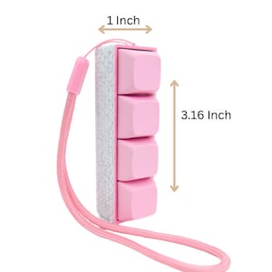 May include: A pink keychain with four square buttons, each with a different design. The keychain is 1 inch wide and 3.16 inches tall.