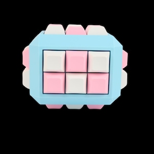 Könnte beinhalten: Ein geometrisches Puzzlespielzeug mit einem hellblauen Rahmen und einer Kombination aus rosa und weißen quadratischen Teilen. Das Spielzeug hat eine Würfelform und ist vor einem schwarzen Hintergrund platziert.