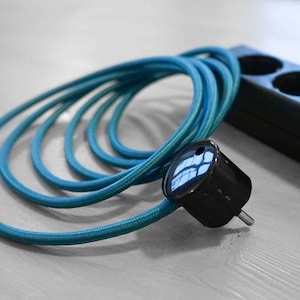 May include: A teal blue electrical cord with a black plug and a black three-outlet power strip.