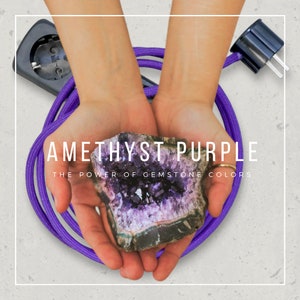 May include: Amethyst purple electrical cord with a purple amethyst gemstone in the center of the image. The text "Amethyst Purple" and "The Power of Gemstone Colors" is displayed below the gemstone.
