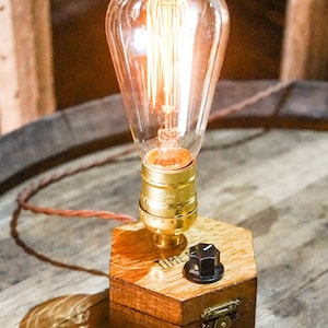 Dimmbare Tischlampe TIMEBULB Dim | Bakelit Knopf Dimmschalter Tischleuchte | Goldene Fassung Edison Birne | Minimalistisches Rustikales Industriedesign Holz Hexagon | Deko Geschenk. Available on Artigiano In Fiera 2024, Milano.