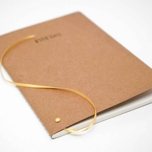 All Natural Notebook TIMEBULB Premium Quality Handcrafted Lined Ecru Kraftpaper Writing Material A5 Easter Home Gift Original Only with the Golden Rivet soft cover
Equipped with Elegant Golden Ribbon Bookmark. Unique and Timeless in Quality and Style