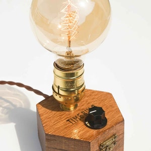 Dimmbare Tischlampe TIMEBULB Dim | Bakelit Knopf Dimmschalter Tischleuchte | Goldene Fassung Edison Birne | Minimalistisches Rustikales Industriedesign Holz Hexagon | Deko Geschenk. Available on Artigiano In Fiera 2024, Milano.