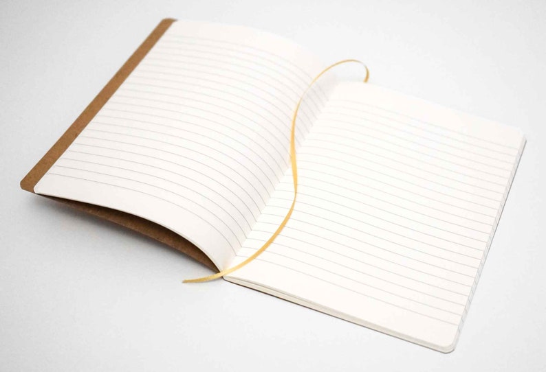 All Natural Notebook TIMEBULB Premium Quality Handcrafted Lined Ecru Kraftpaper Writing Material A5 Easter Home Gift Original Only with the Golden Rivet soft cover
Equipped with Elegant Golden Ribbon Bookmark. Unique and Timeless in Quality and Style