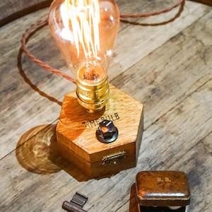Dimmbare Tischlampe TIMEBULB Dim | Bakelit Knopf Dimmschalter Tischleuchte | Goldene Fassung Edison Birne | Minimalistisches Rustikales Industriedesign Holz Hexagon | Deko Geschenk. Available on Artigiano In Fiera 2024, Milano.